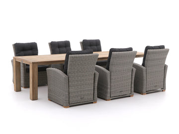 Tuinset van vlechtwerk met zes stoelen met kussens en een houten tafel.